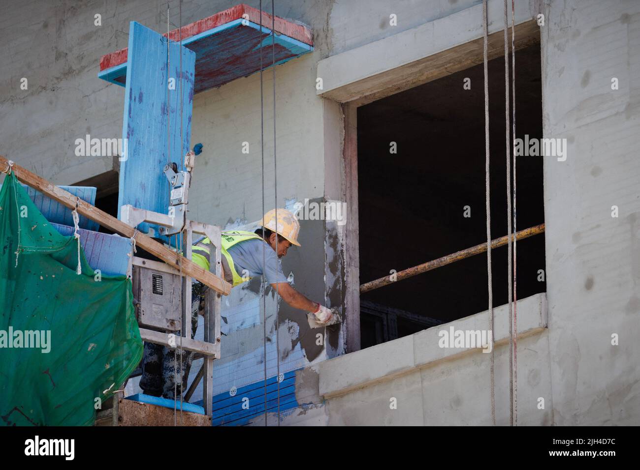 Un uomo lavora in un cantiere di costruzioni di appartamenti a Pechino, Cina, 15 luglio 2022. REUTERS/Thomas Peter Foto Stock