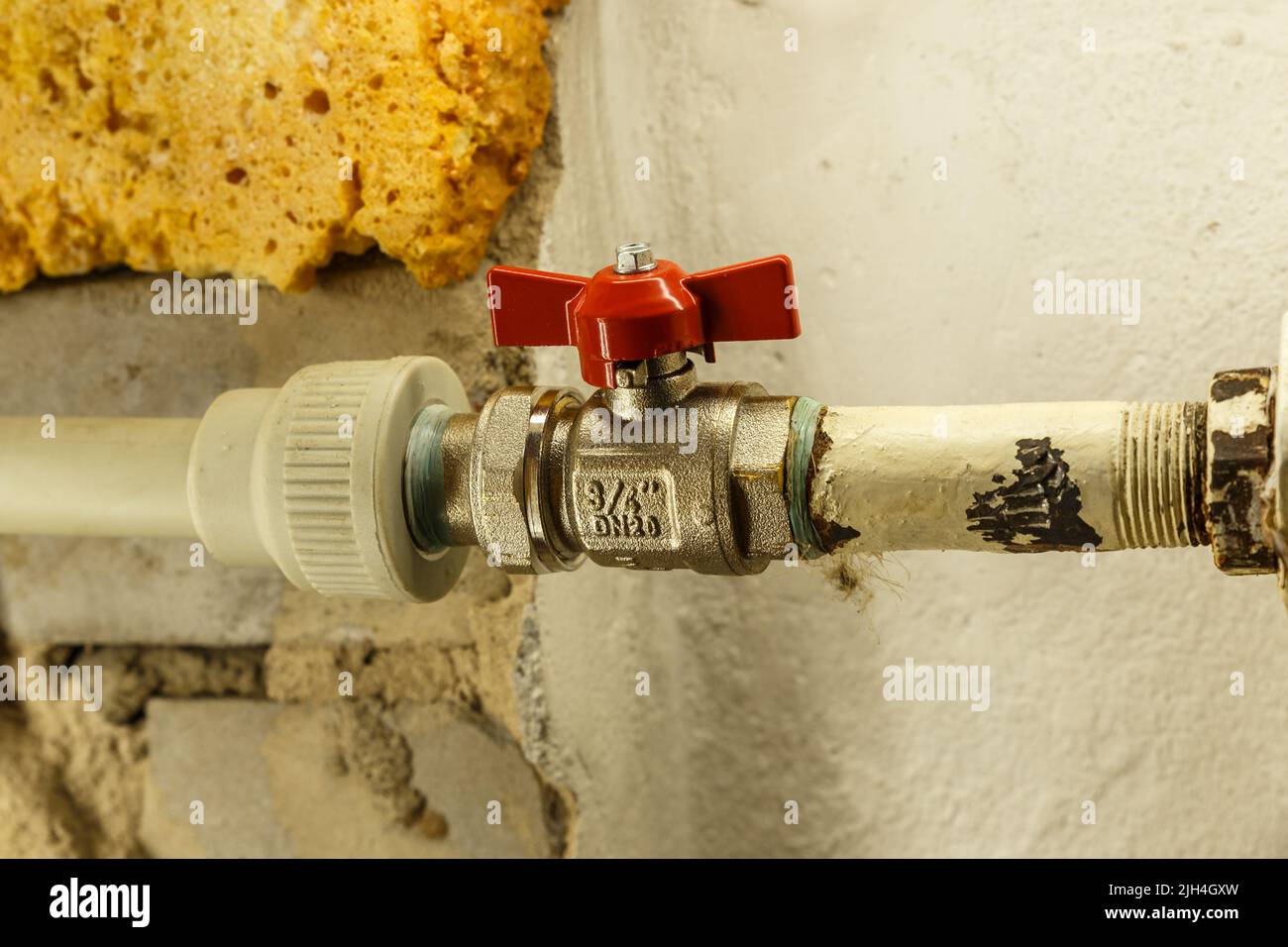 rubinetto d'acqua rosso su una batteria di riscaldamento. Riscaldamento appartamento in inverno. Foto Stock