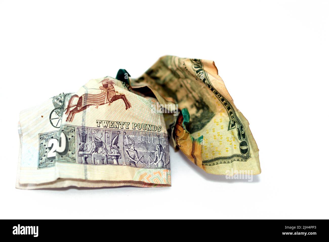 Crumpled rugged American money note di 20 $ venti dollari fattura e 20 LE venti egiziano banconote in contanti isolato su sfondo bianco, econom Foto Stock