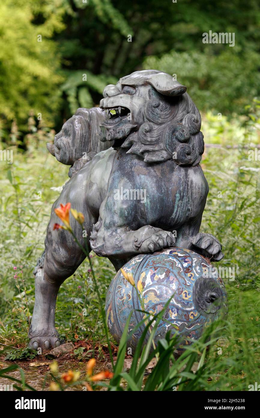 Scultura cinese del cane del foo del bronzo e dello smalto a Batsford Arboretum, Cotswolds Regno Unito Foto Stock