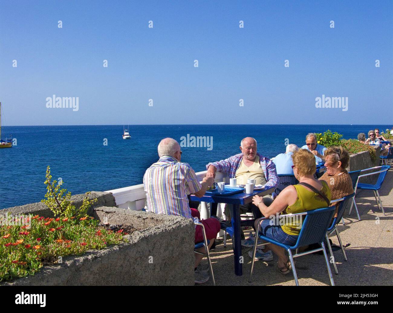 Anziani, anziani seduti sul lungomare, Arguineguin, Grand Canary, Isole Canarie, Spagna, Europa Foto Stock