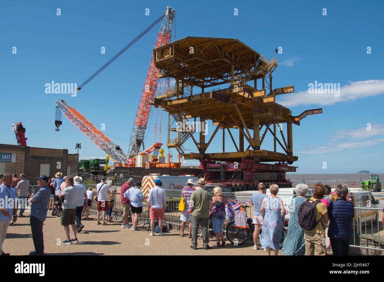 Weston-super-Mare, Somerset, Regno Unito. 15th luglio 2022. La piattaforma del Mare del Nord, alta 25 metri, è stata un'installazione d'arte chiamata il mostro See che si trova sulla spiaggia di Weston-Super-Mare in Somerset per essere sollevato sulle sue gambe già installate accanto al Tropicana. Una grande folla si sta costruendo sul lungomare in attesa dell'ascensore che si prevede accadrà oggi. Picture Credit: Graham Hunt/Alamy Live News Foto Stock