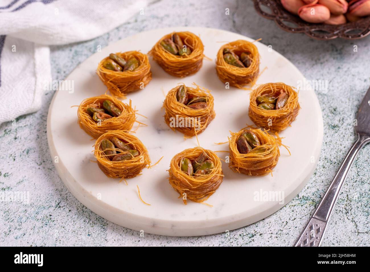 Bulbul Kadayif con Pistacchio. Kadayif baklava con riempimento di pistacchio su un pavimento di pietra. Dessert di cucina turca. Primo piano. Nome locale Antep Fıstıklı Foto Stock