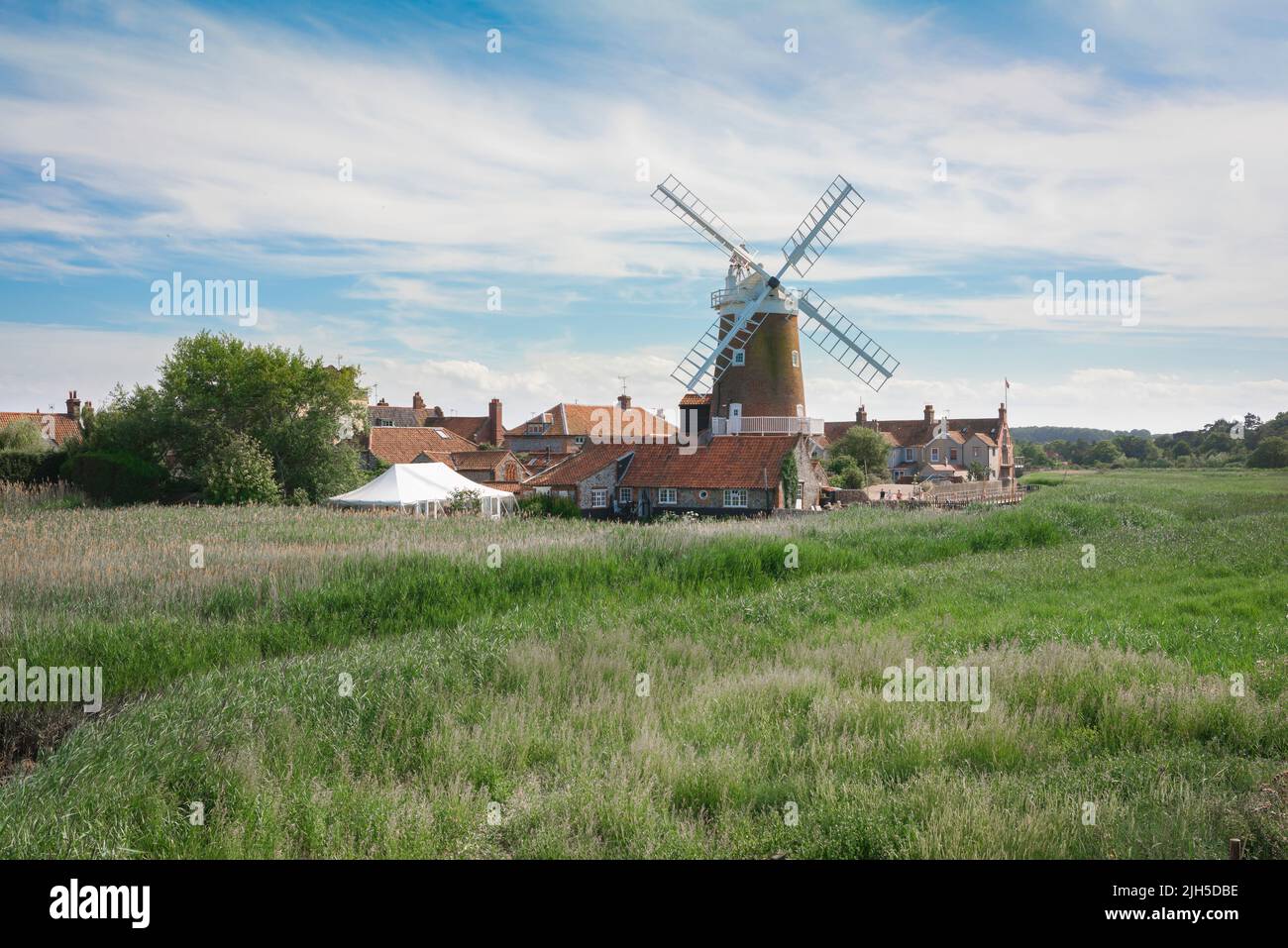 Windmill UK Inghilterra, vista in estate attraverso Cley Marshes verso il mulino a vento 18th secolo a Cley accanto al mare, North Norfolk costa, Inghilterra, Regno Unito Foto Stock