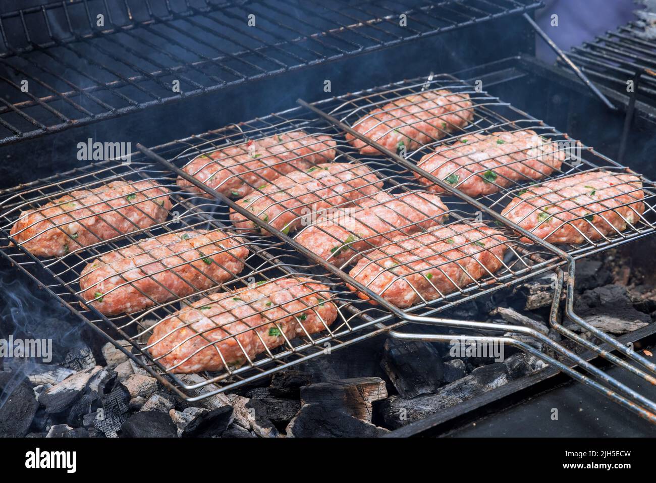 Grigliate americane miste su una griglia calda con hamburger e arrosti di manzo Foto Stock