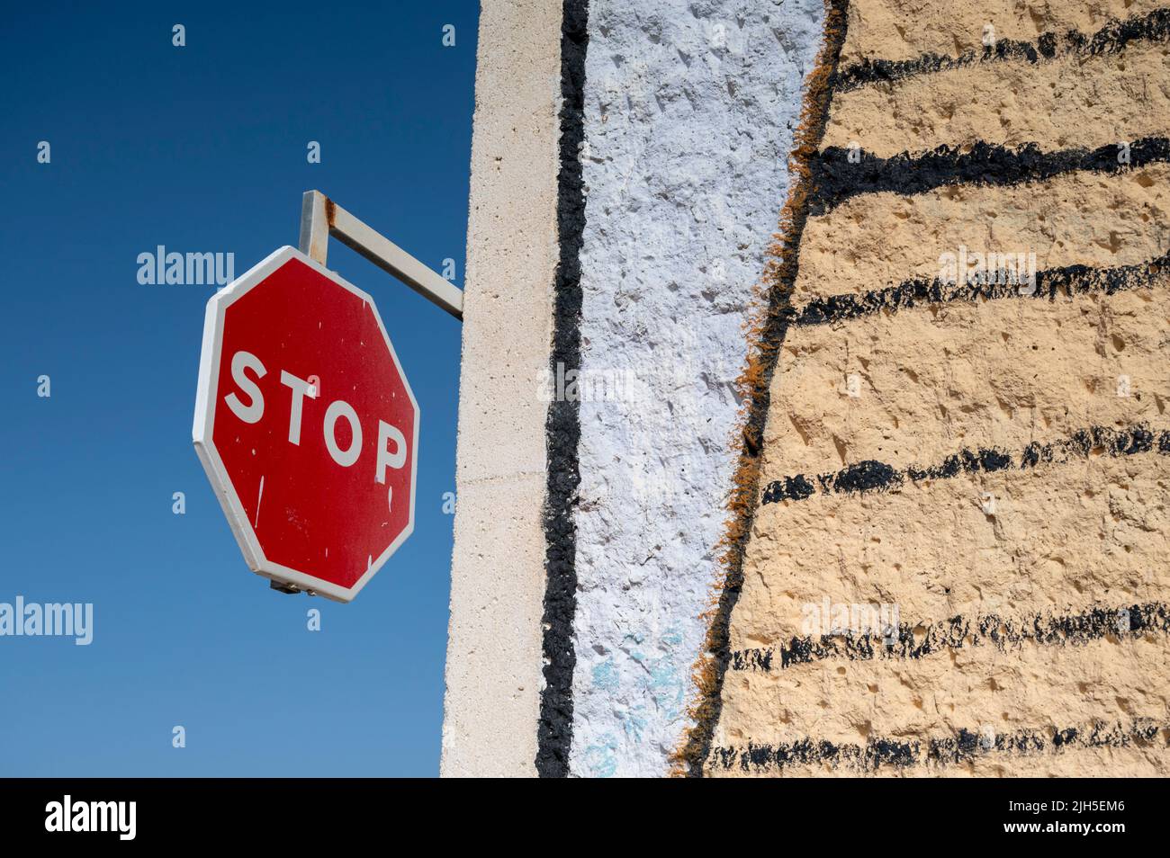 Un cartello rosso di stop su un muro che è stato dipinto con opere d'arte che formano un design colorato nel porto turistico di Rota Spagna Foto Stock