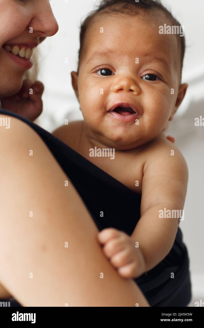 Sorridendo adorabile bambino con felice madre in imbracatura Foto Stock