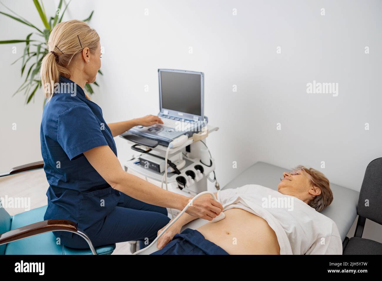 Medico ecografia esaminare paziente anziano addome in ospedale. Centro di diagnosi prenatale Foto Stock