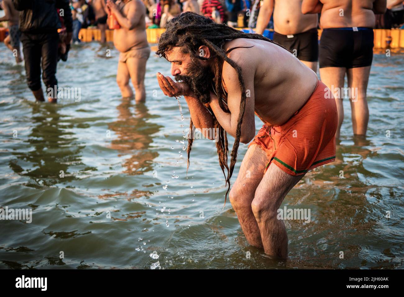 Un uomo indù beve e bagna nelle acque sacre al Triveni Sangam al Kumbh Mela Festival ad Allahabad (Prayagraj), Utar Pradesh, India. Foto Stock
