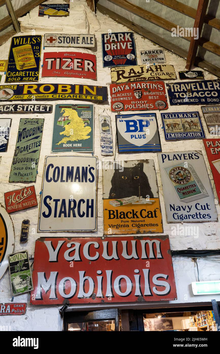 Collezione di insegne pubblicitarie inglesi vintage esposte su pareti bianche Foto Stock