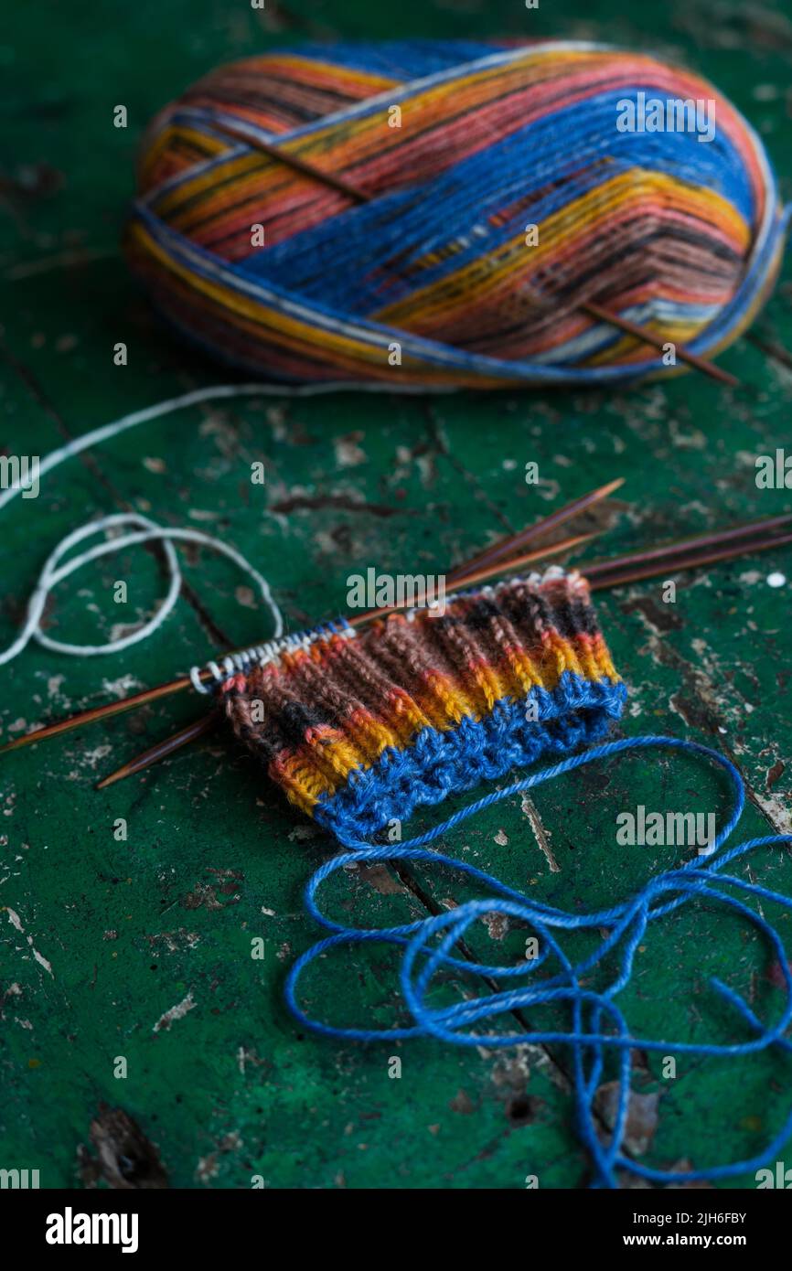Calzino lavorato a mano, a maglia con aghi e lana Foto Stock