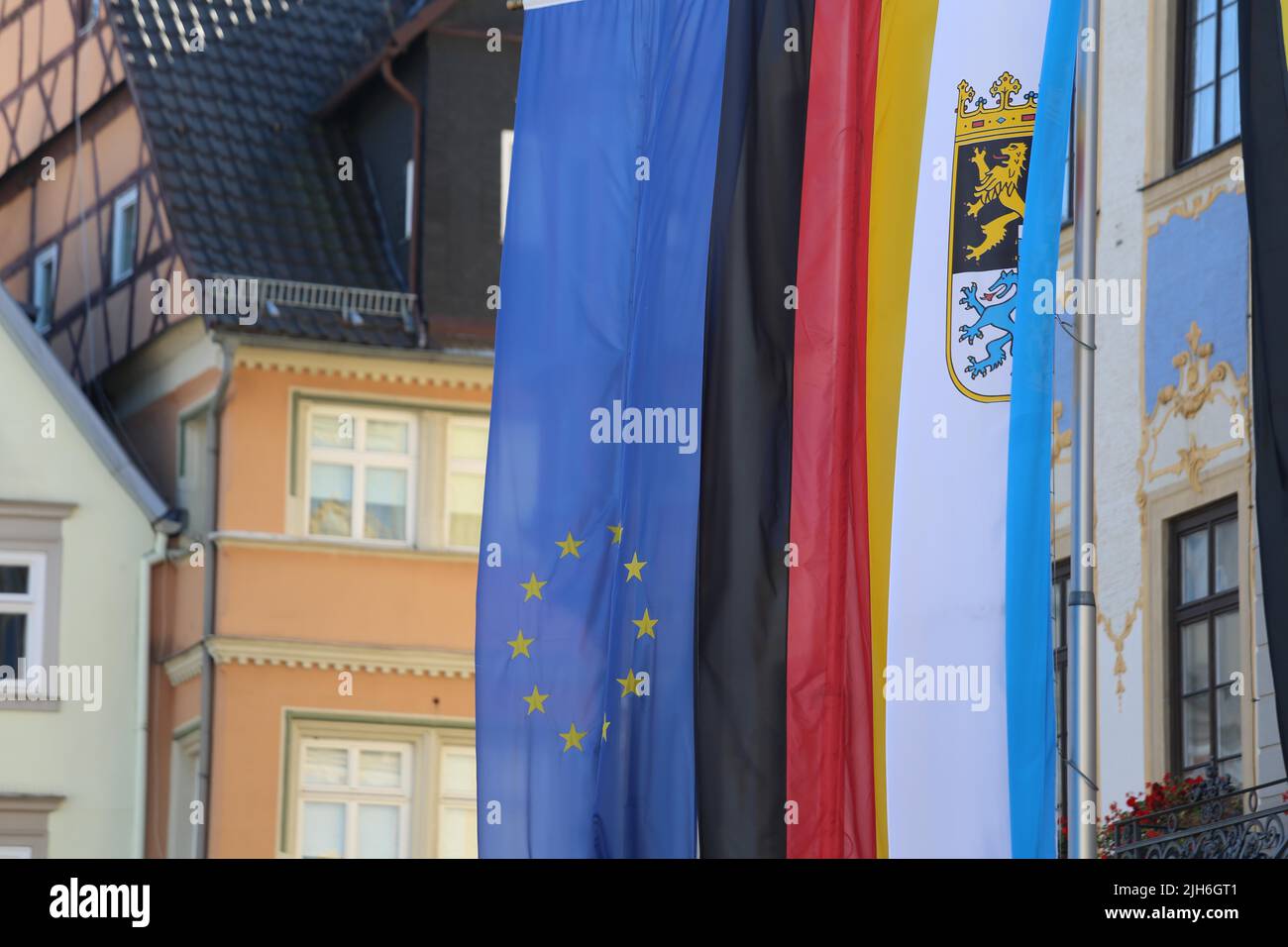 La bandiera bavarese appesa al di fuori di un municipio di accanto alle bandiere dell'UE e della Germania. Coburg, Germania Foto Stock