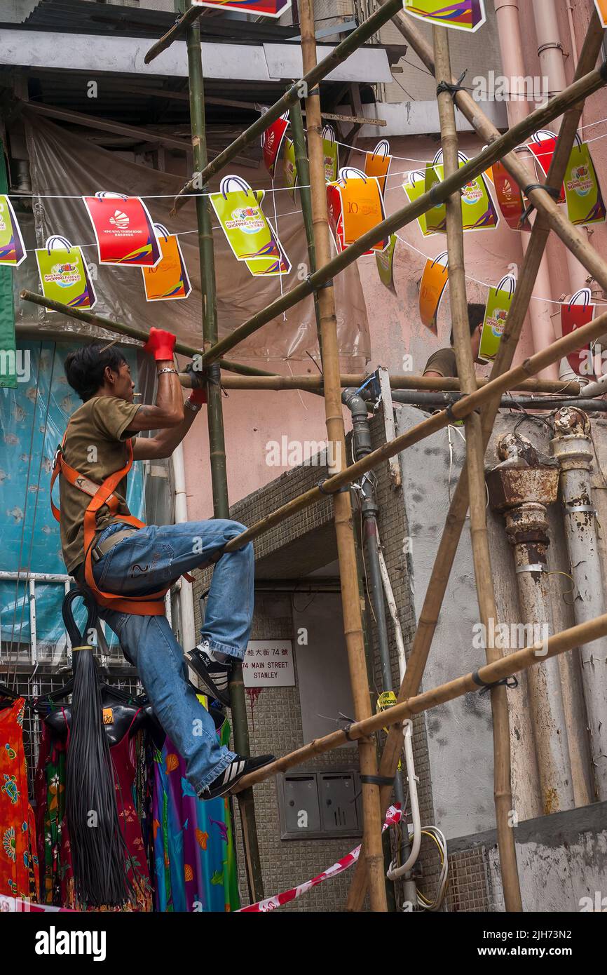 Un lavoratore costruisce impalcature da bambù e cravatte di plastica, Stanley, Hong Kong Island Foto Stock