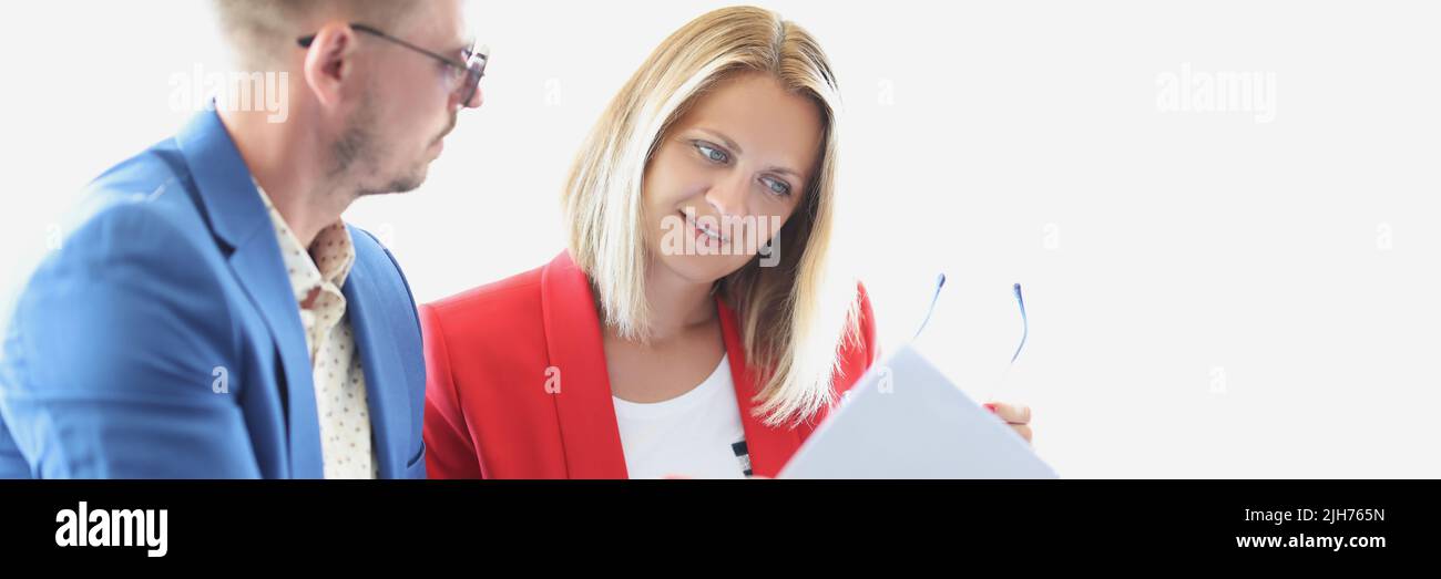 La donna concentrata passa attraverso i documenti di affari per rimuovere gli errori Foto Stock