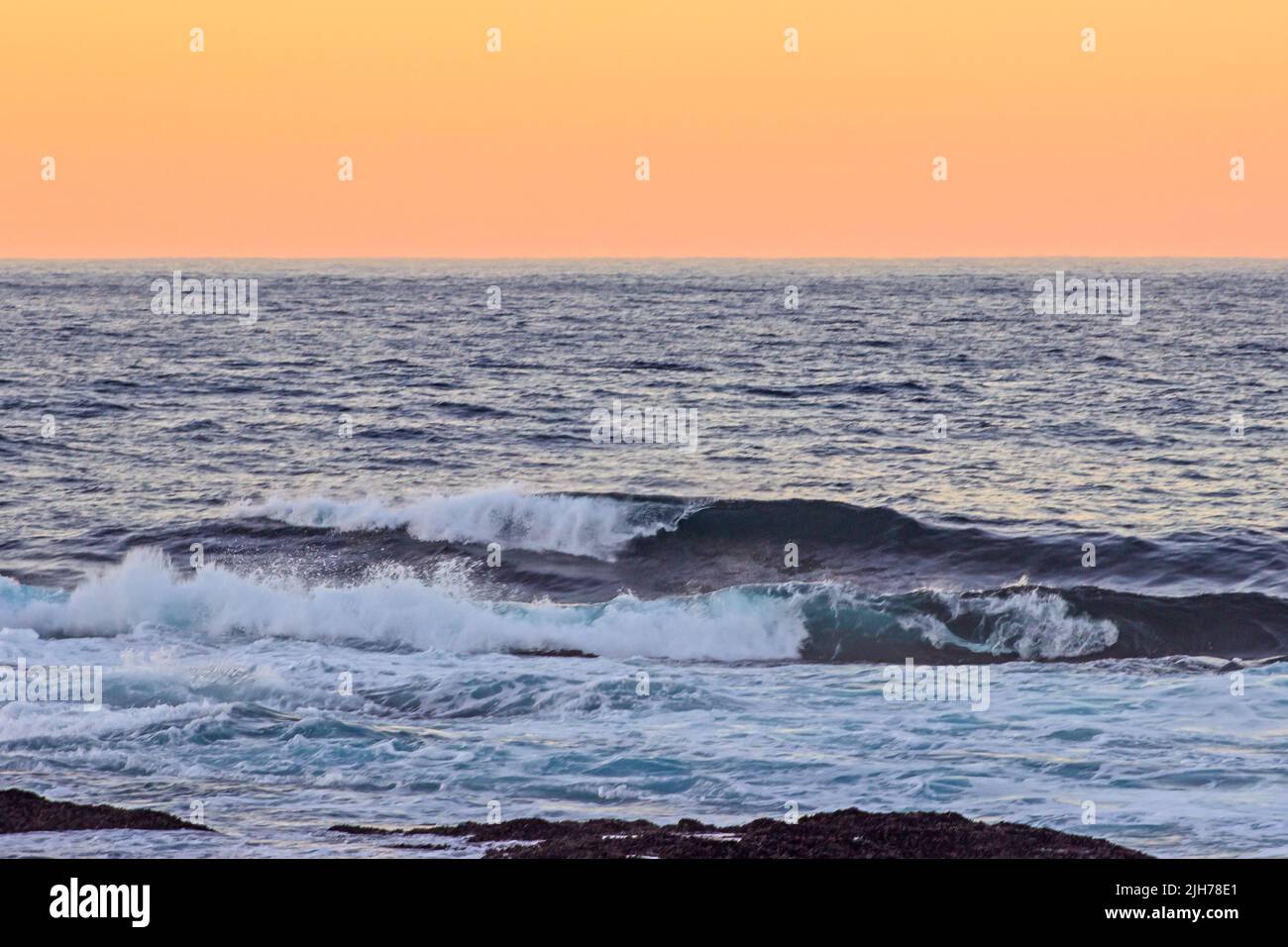 Onde che si infrangono all'alba nell'Oceano Indiano meridionale, della costa nella Garden Route, Sudafrica Foto Stock