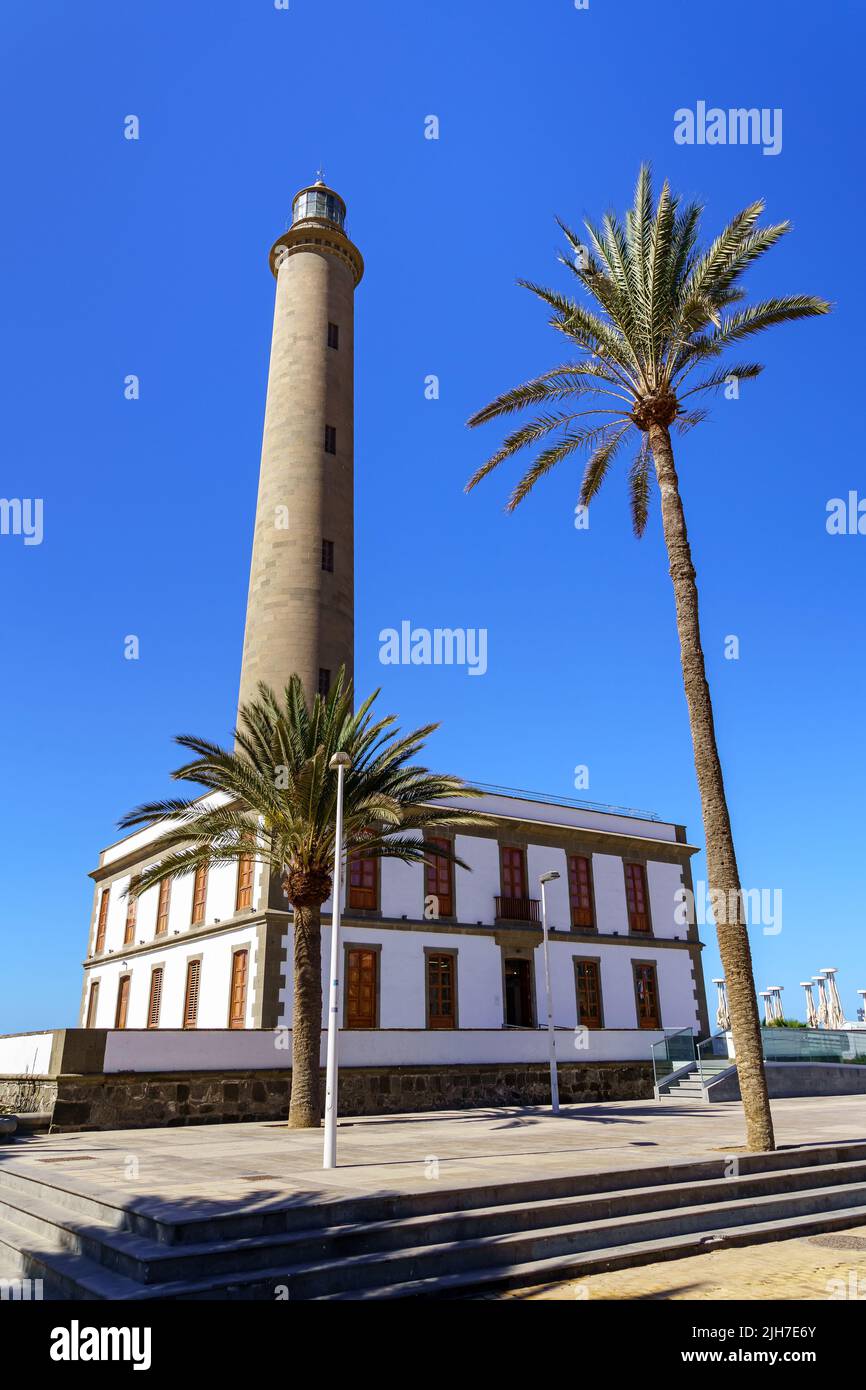 Alto faro su cielo blu in estate accanto a una grande palma verde sulla spiaggia di Maspalomas nelle Isole Canarie. spagna Foto Stock