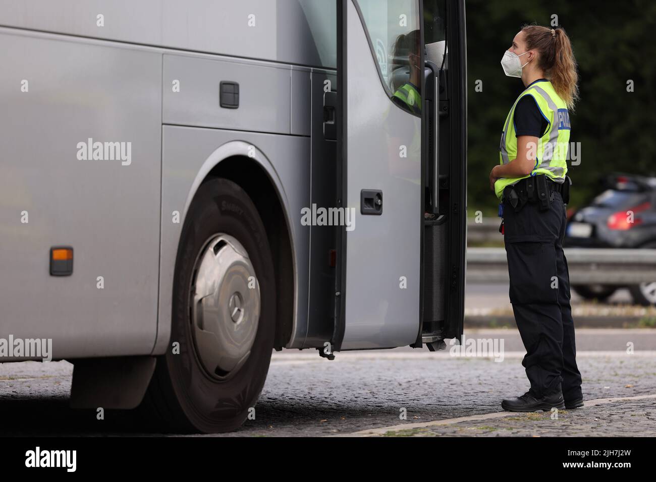 Ratingen, Germania. 16th luglio 2022. Un poliziotto controlla un pullman presso l'area di servizio Hösel sulla superstrada A3 vicino Ratingen. La polizia utilizza il punto intermedio delle vacanze estive come opportunità per controlli sul traffico a livello nazionale. Credit: David Young/dpa/Alamy Live News Foto Stock