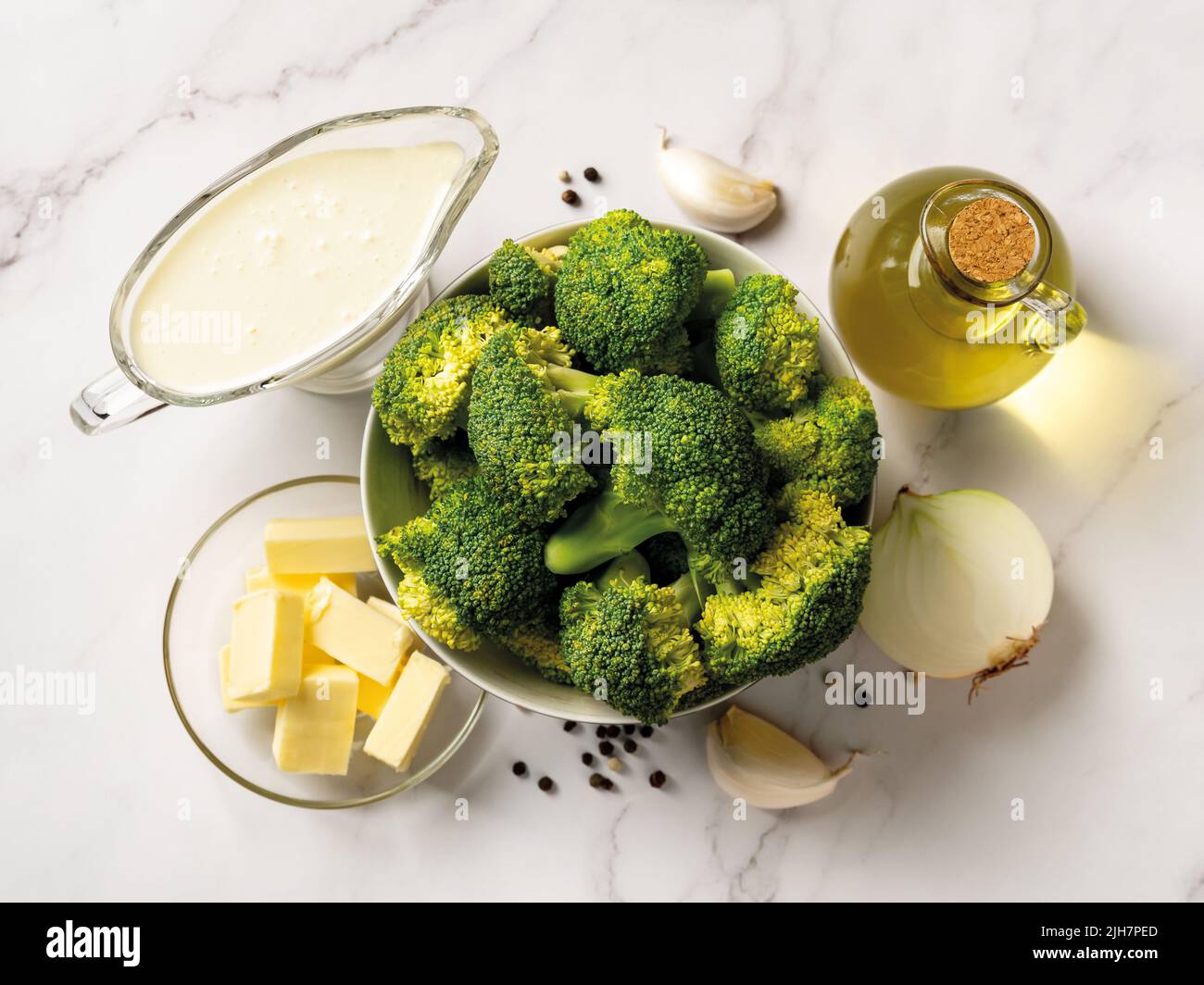 Ingredienti crudi per la cottura della crema di broccoli: Broccoli, panna, burro, aglio, cipolla e olio d'oliva. Minestra purea di broccoli ricetta. Foto Stock
