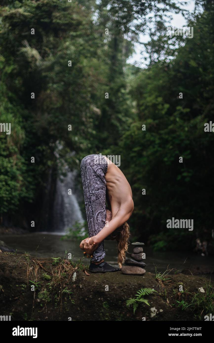 Pratica di yoga e meditazione in natura. Uomo che pratica vicino al fiume Foto Stock