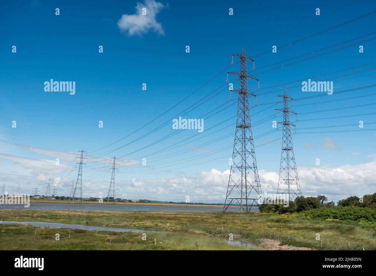 Un paio di piloni elettrici alti che trasportano cavi attraverso l'estuario di Lune vicino Lancaster, Inghilterra, Regno Unito Foto Stock