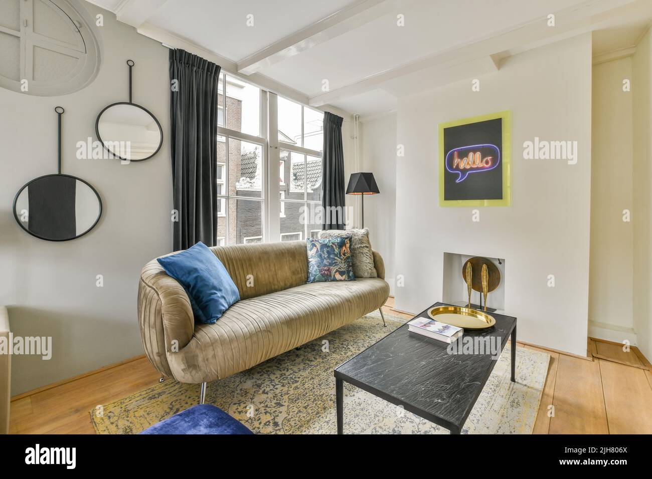 Comodo divano e posto su morbido tappeto vicino alle finestre in un accogliente e luminoso soggiorno in appartamento moderno Foto Stock