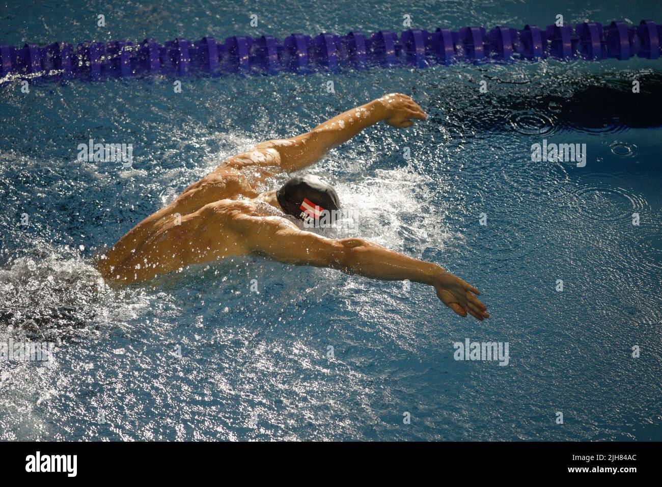 Otopeni, Romania - 8 luglio 2022: Dettagli con un atleta professionista austriaco maschio nuoto in una piscina olimpionica farfalla stile. Foto Stock