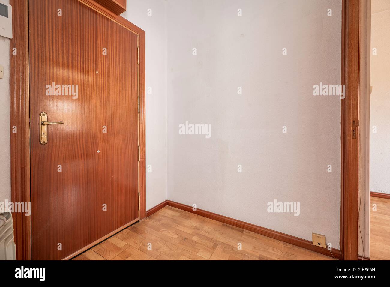 Ingresso di una casa con pavimenti in parquet, legno di mogano e pareti dipinte di bianco Foto Stock