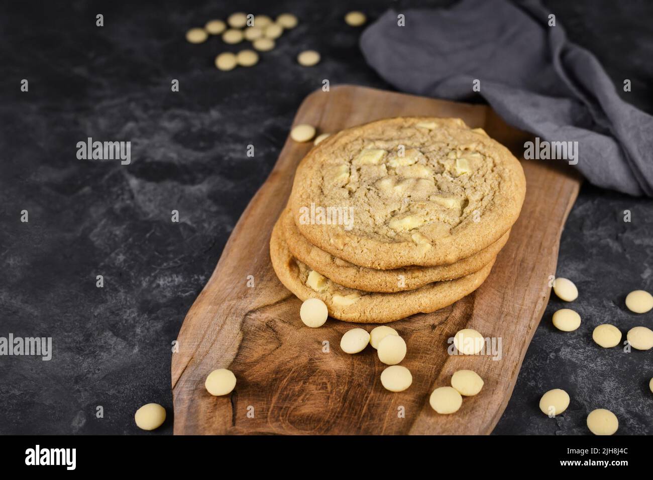 Biscotti con gocce di cioccolato bianco su tavola di legno Foto Stock