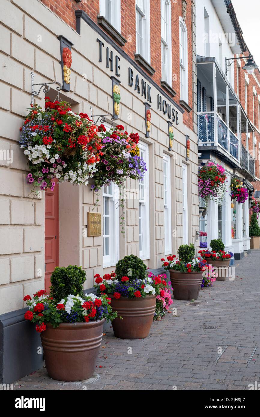 Cestini appesi e vasi di fiori fuori dalla Bank House nella città di Pershore, Worcestershire, Regno Unito Foto Stock