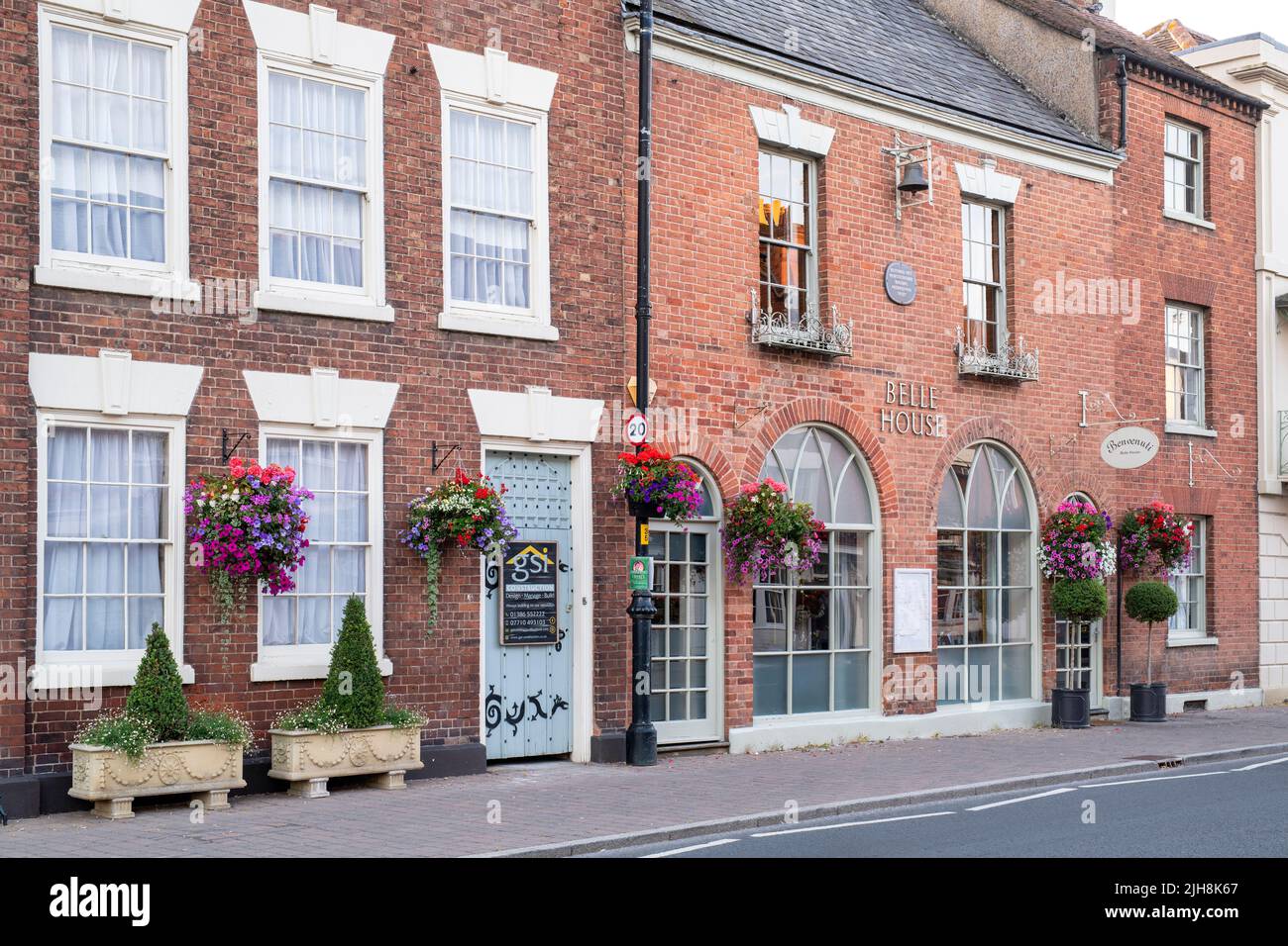 Nei cestini appesi di fiori su fronti di casa nella città di Pershore, Worcestershire, Regno Unito Foto Stock