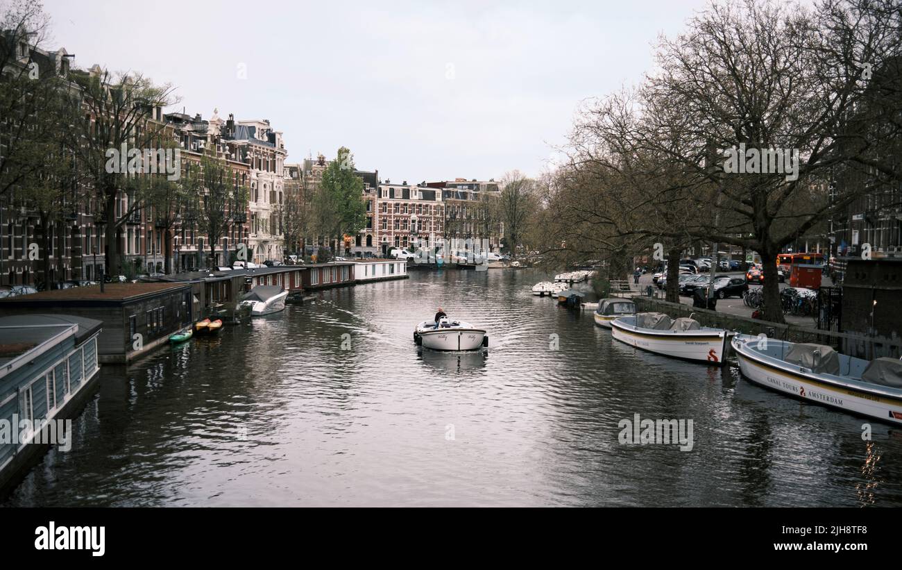 Una vista panoramica di una barca che scende lungo un canale ad Amsterdam, Paesi Bassi Foto Stock