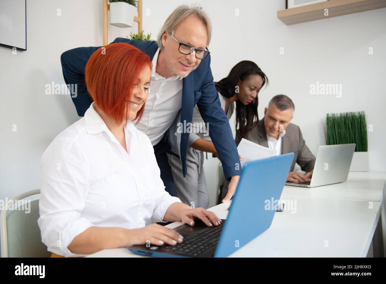 Business team di uomini e donne in un ufficio che analizza l'evoluzione dell'azienda Foto Stock
