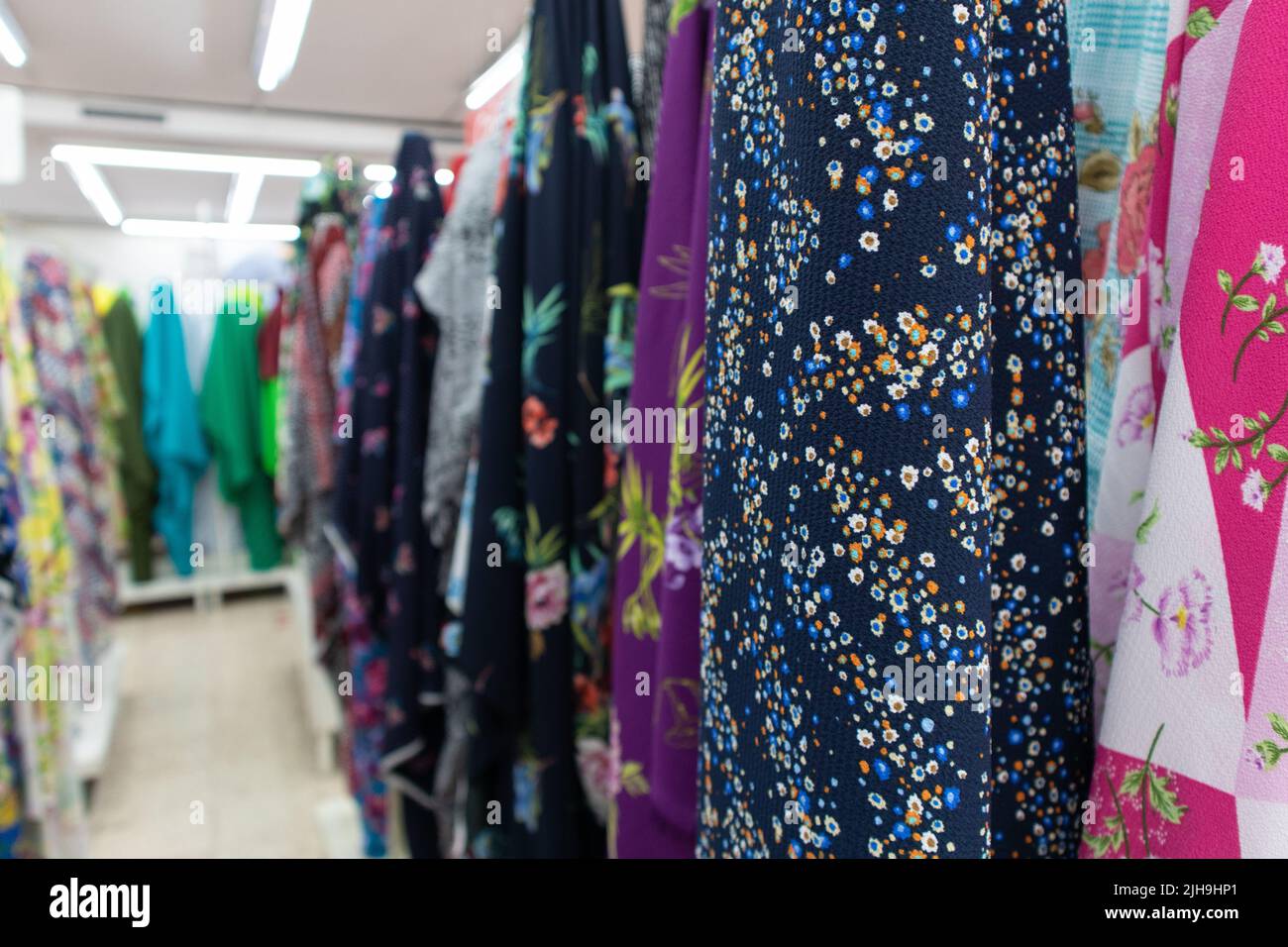 pila di rotoli colorati multipli di stoffa in vendita in un negozio di tessuti Foto Stock
