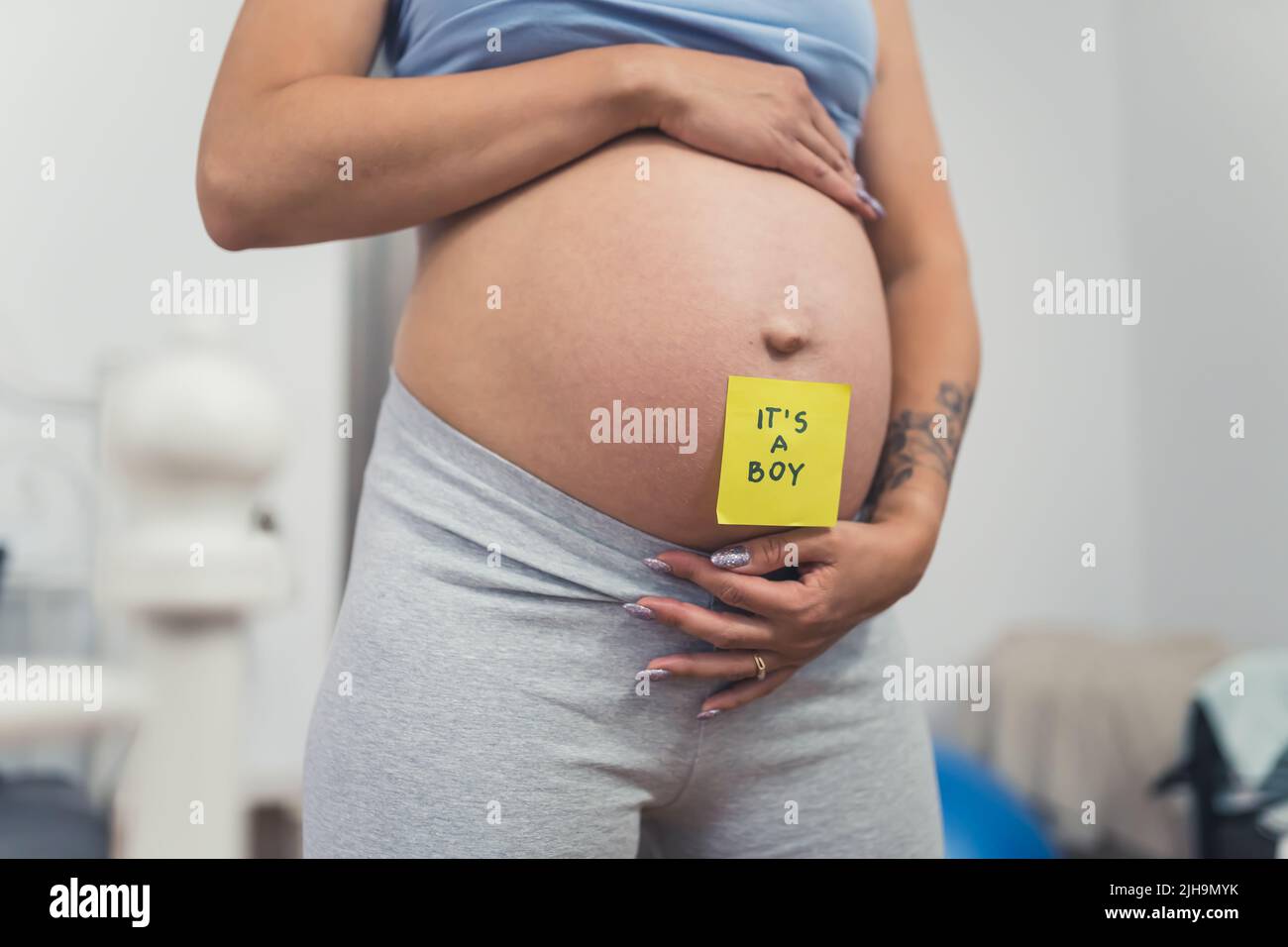 ventre della donna incinta con una nota appiccicosa che dice ragazzo, primo piano genere rivelare concetto. Foto di alta qualità Foto Stock