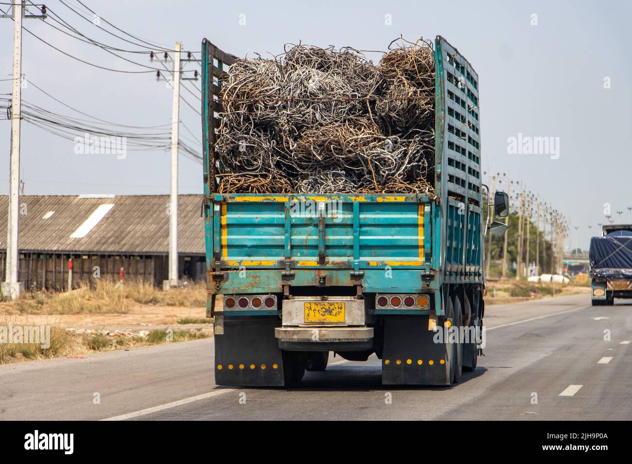 Il carrello trasporta i cavi di ferro sull'autostrada, vista laterale posteriore Foto Stock