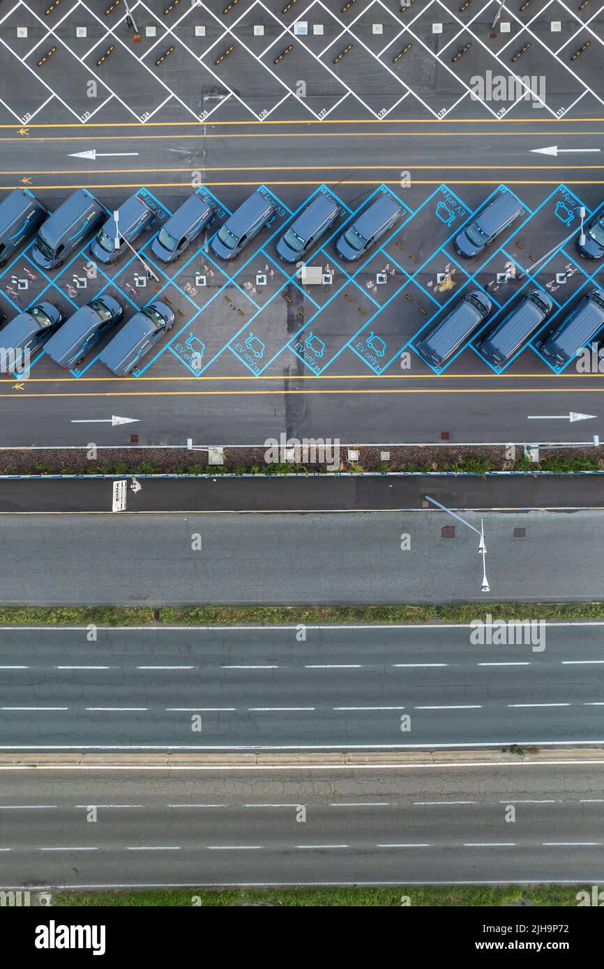 Vista dall'alto dei furgoni elettrici Amazon prime, parcheggiati presso il centro logistico di Amazon. Torino, Italia - Luglio 2022 Foto Stock