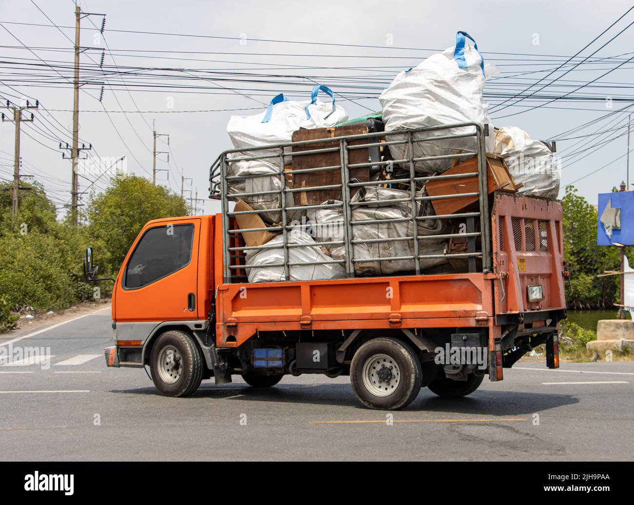 Un camion carico di sacchi grandi e vecchi mobili giro su una strada di campagna Foto Stock