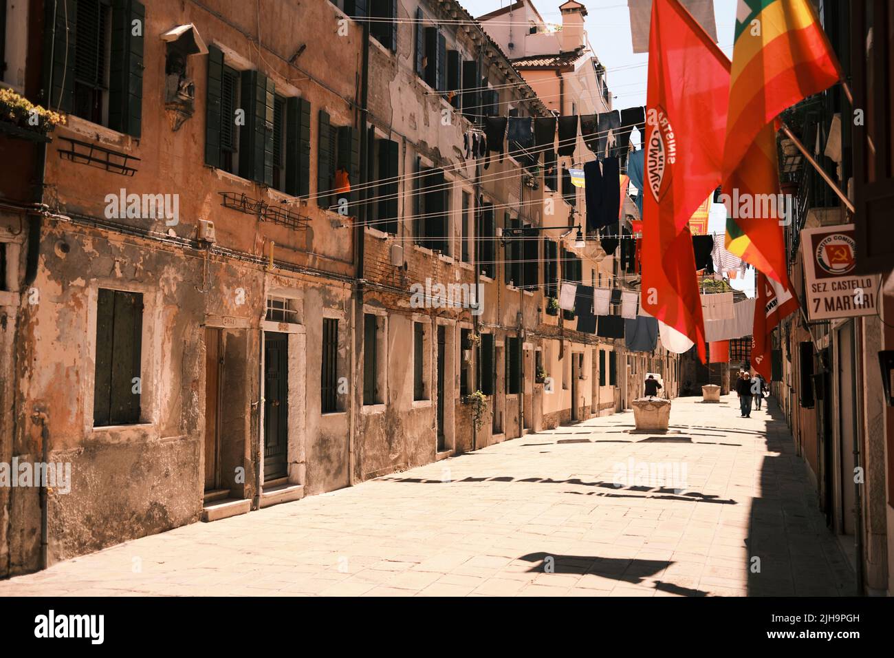 Le bandiere, il negozio di lavanderia, e vecchi edifici della città di Venezia in Italia Foto Stock
