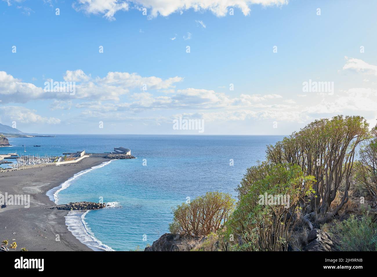 Mare panoramico e mare della città costiera turistica di Puerto de Tazacorte a la Palma, Spagna durante l'estate. Vista panoramica di un mare con un nero Foto Stock
