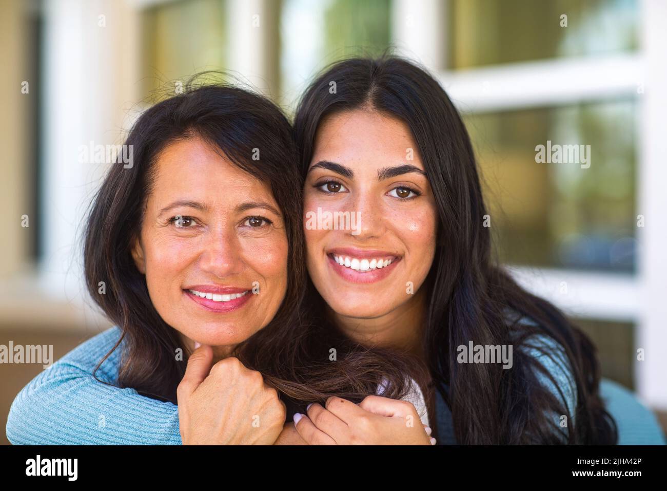 Madre e sua figlia adulta che abbraccia e ride Foto Stock