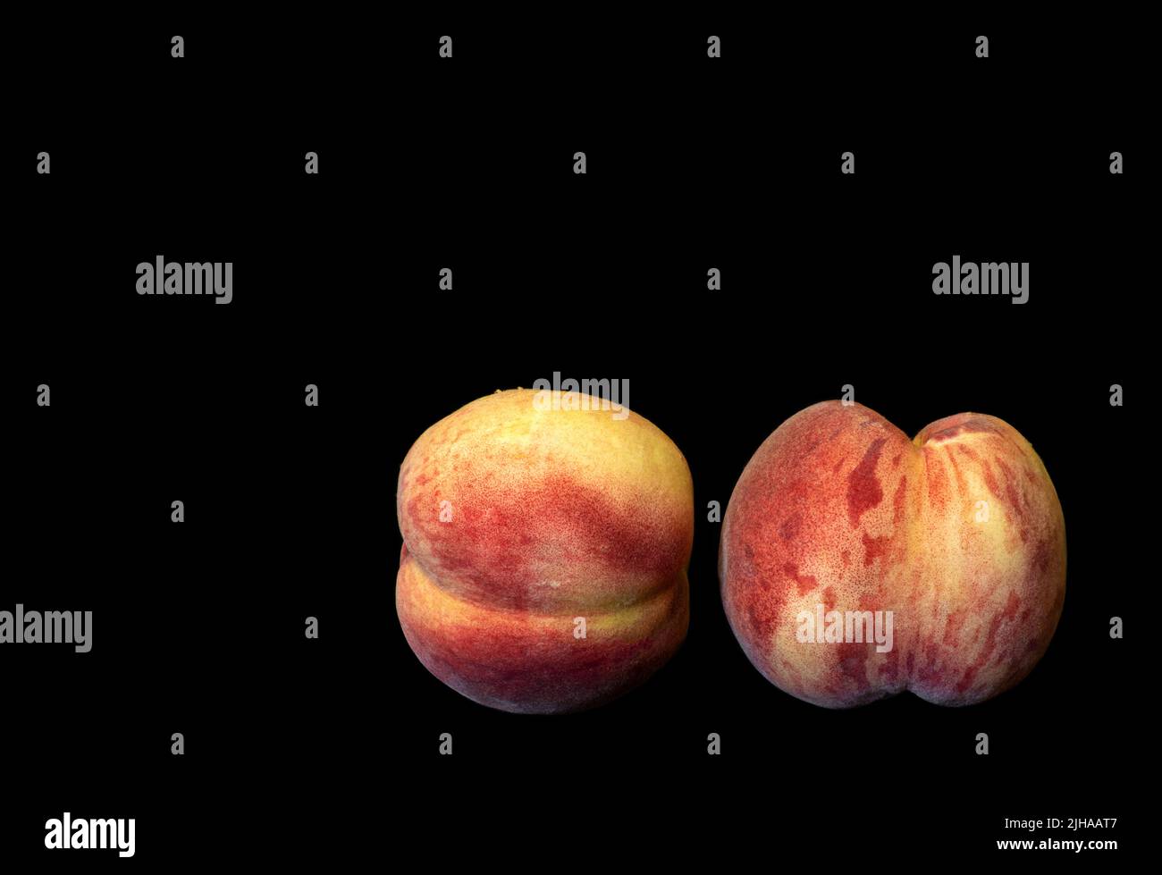 Immagine di due pesche mature su sfondo nero Foto Stock