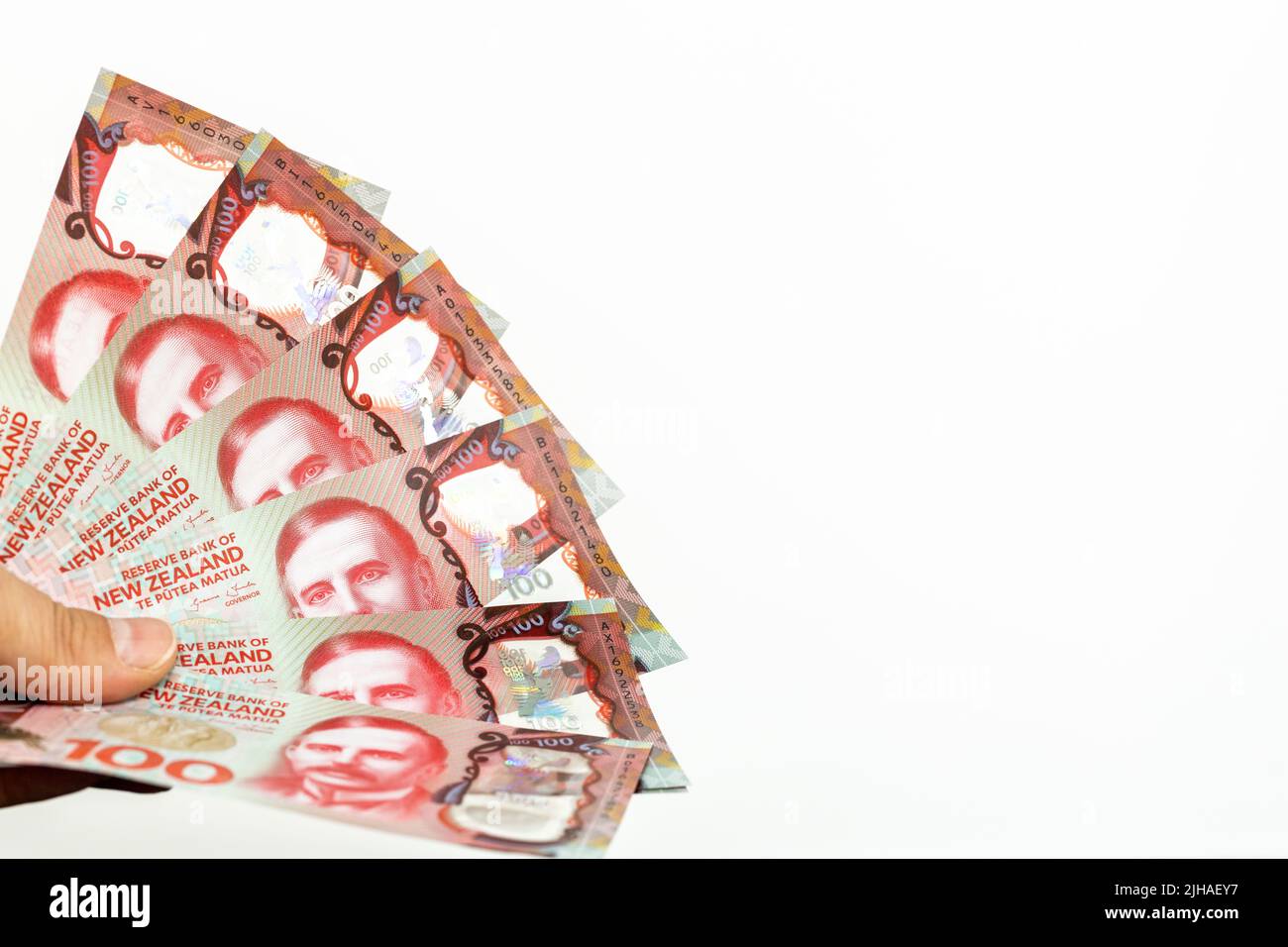 Un archivio di dollari della Nuova Zelanda tenuto in mano su uno sfondo bianco, spazio per un'iscrizione Foto Stock
