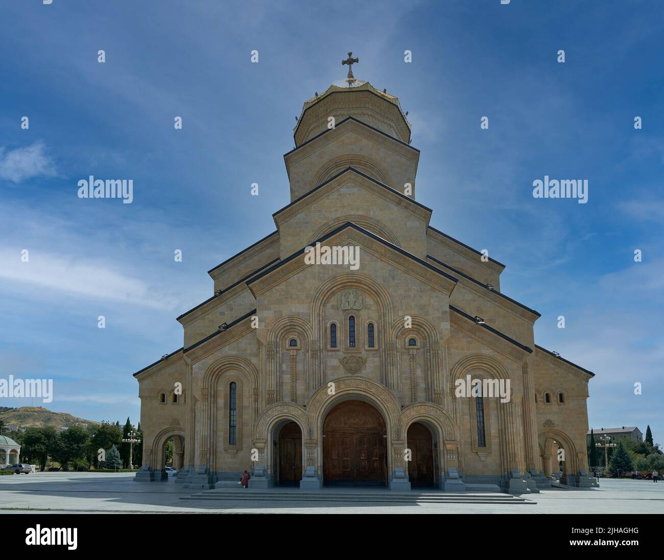 La Cattedrale della Santissima Trinità di Tbilisi, Georgia, con vista esterna della luce del giorno che mostra l'architettura unica della cattedrale con persone che camminano sulle scale Foto Stock