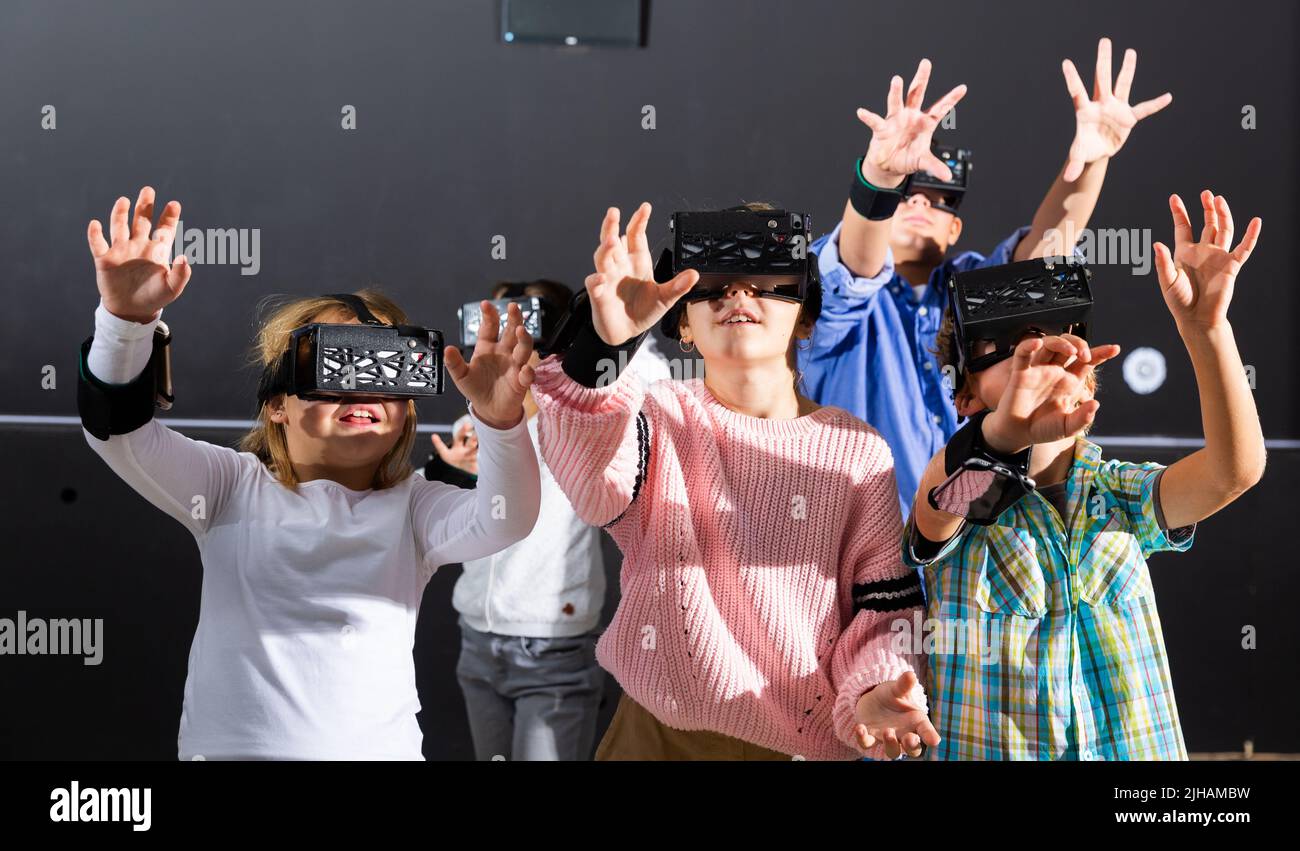 I bambini cercano una via d'uscita dalla stanza di fuga virtuale Foto Stock