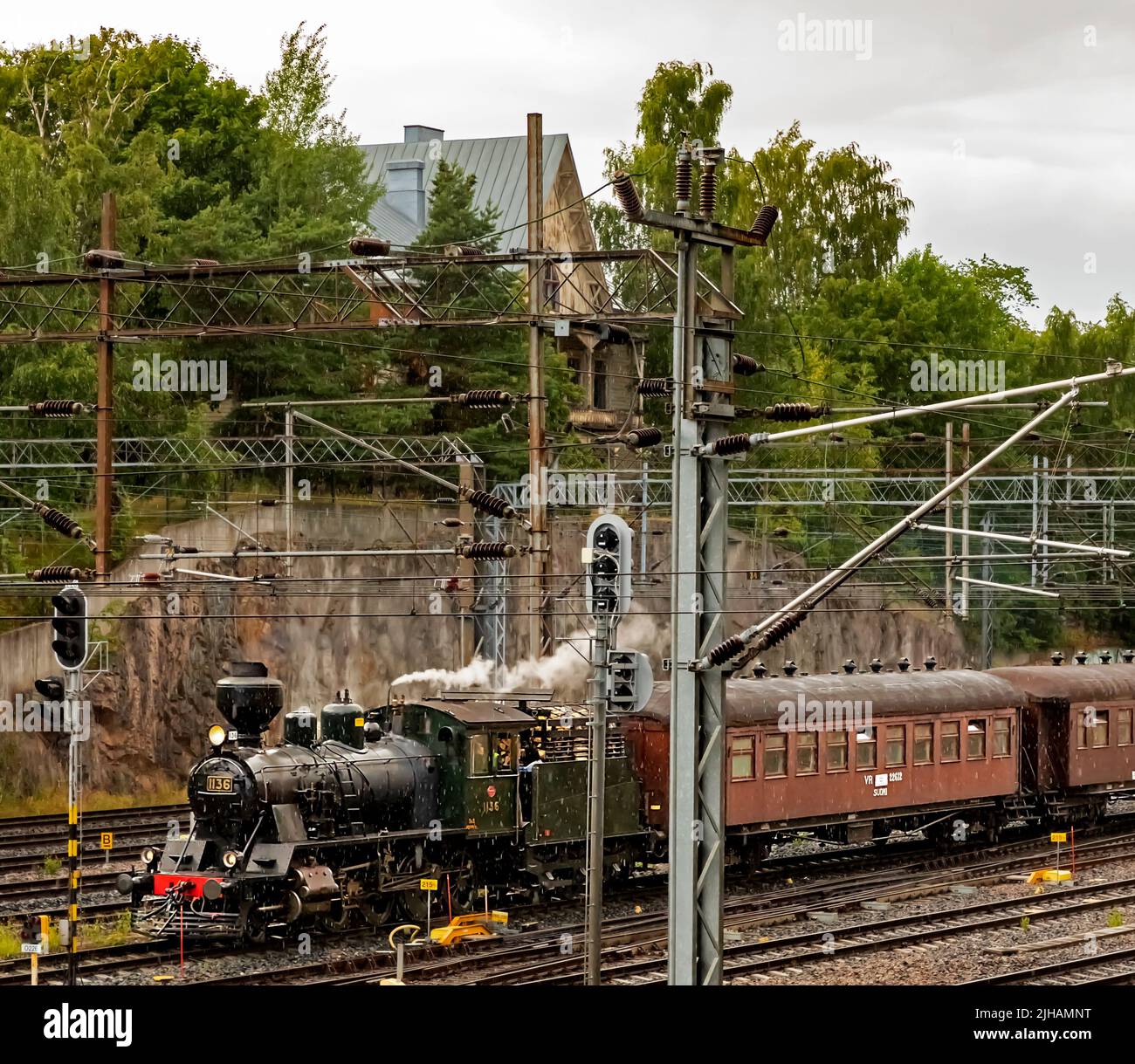 Locomotiva a vapore Tk3 1136 che tira un treno attraverso il taglio Linnunlaulu a Helsinki, Finlandia Foto Stock