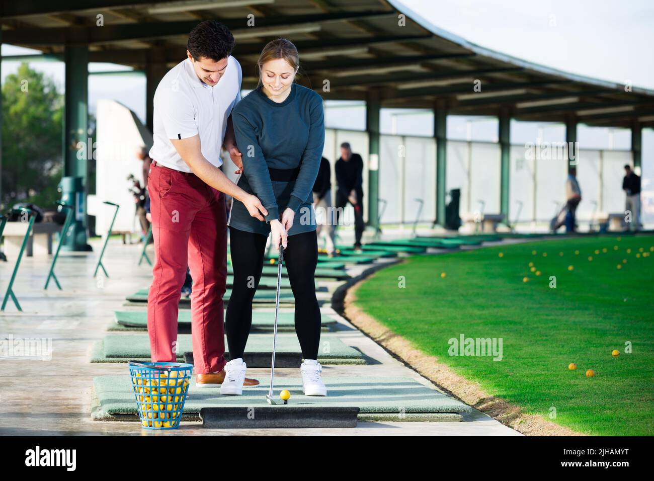 Il golf del giocatore aiuta la ragazza a padroneggiare le abilità Foto Stock