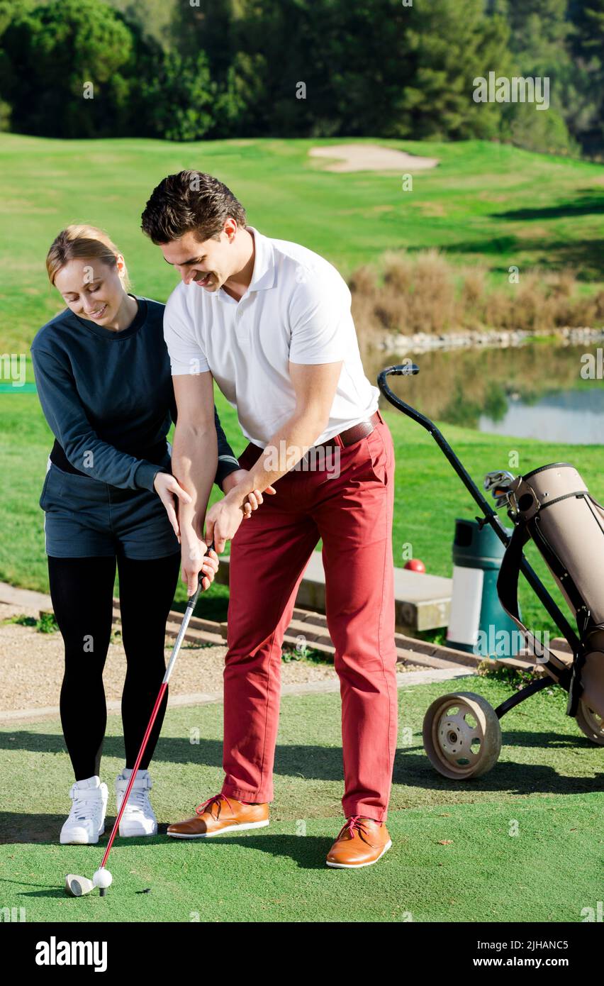Donna golfer che addestrano l'uomo per giocare il golf Foto Stock