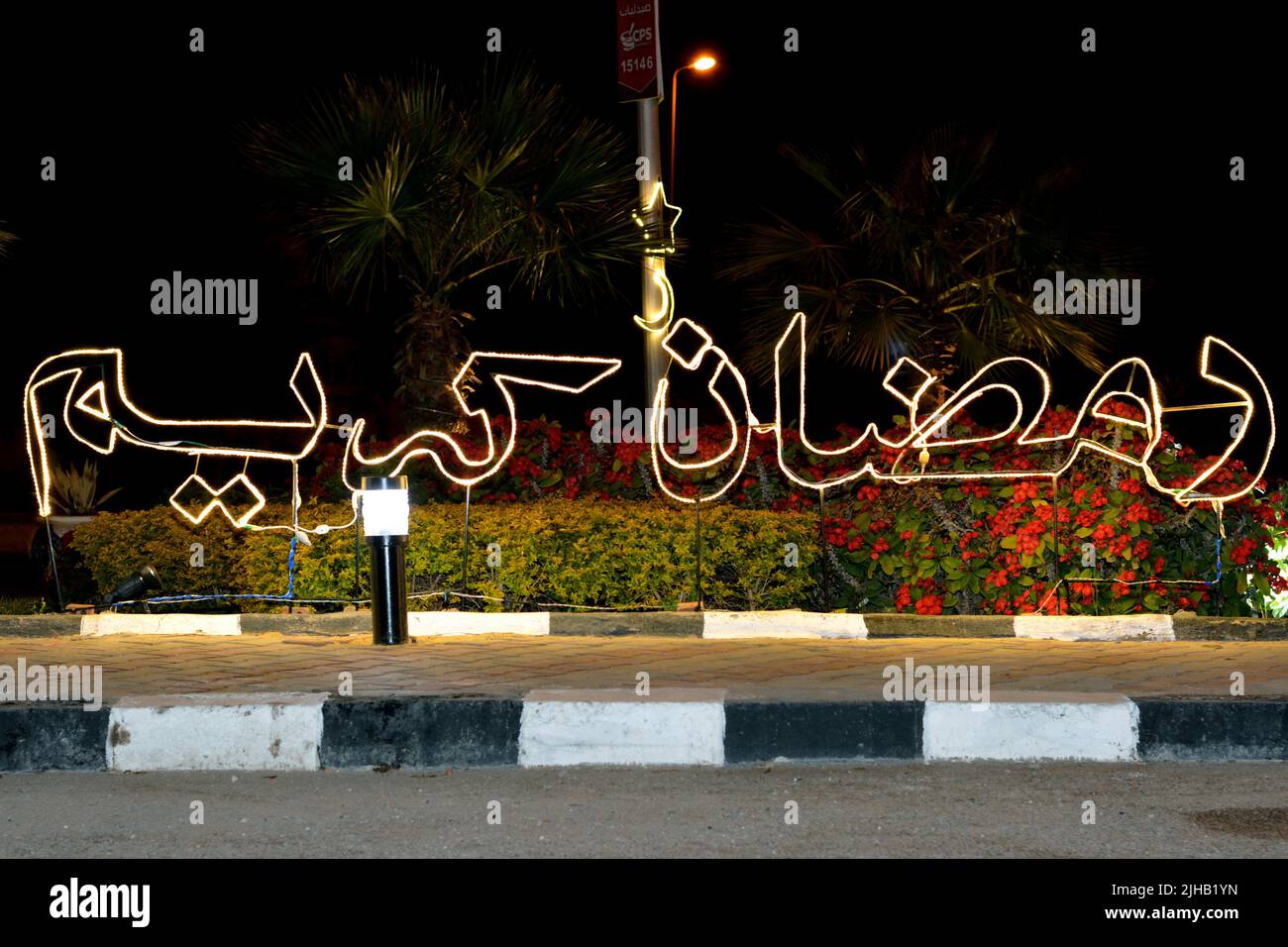 Cairo, Egitto, 25 2022 marzo: Un testo arabo Ramadan Kareem, traduzione (generoso felice Ramadan) fatto con luci a LED in strada come un segno di festa Foto Stock