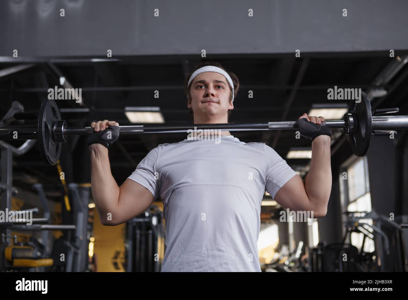 Scatto ad angolo basso di uno sportivo che fa esercizio con barbell push press Foto Stock