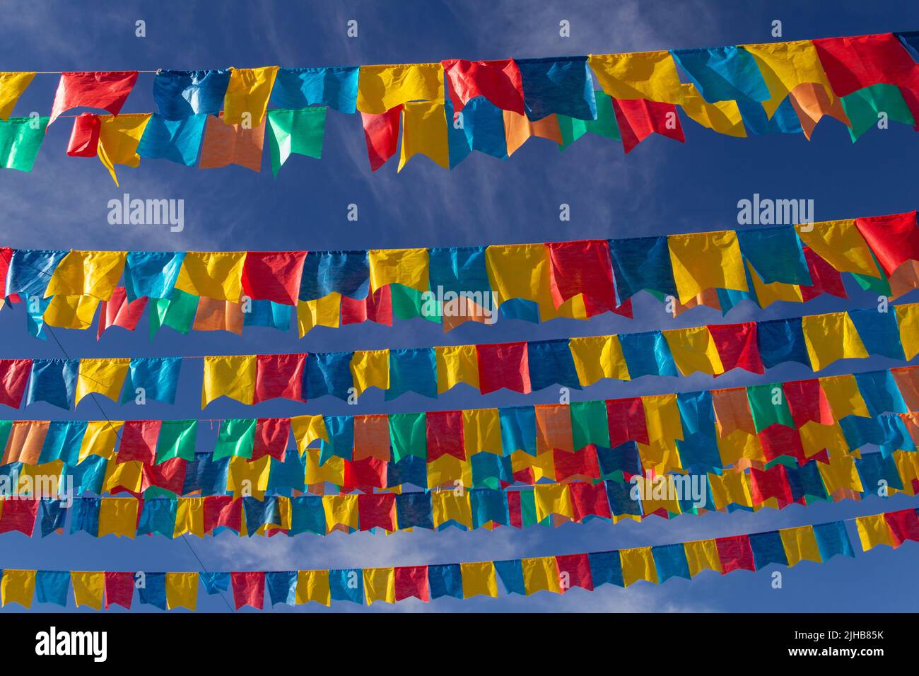 Goiania, Goiás, Brasile – 17 luglio 2022: Diverse linee di abbigliamento con bandiere di tessuto contro il cielo blu per la festa di giugno - tipico brasiliano 'Quadrilha' Foto Stock